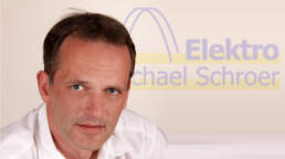 michael schroer vor seinem firmenlogo elektro michael schroer